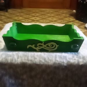 Wooden green tray with decorative pieces on front and same on back.